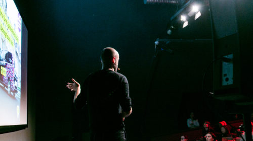 A photo of a team member on stage at a Factory Berlin event.