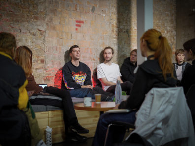 A group of artists in residence sit around their mentor Dixon.