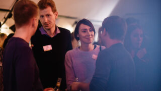 Members of the Factory Berlin community networking and in discussion at an event.