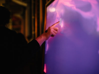 A person engages with an interactive art installation at an event.